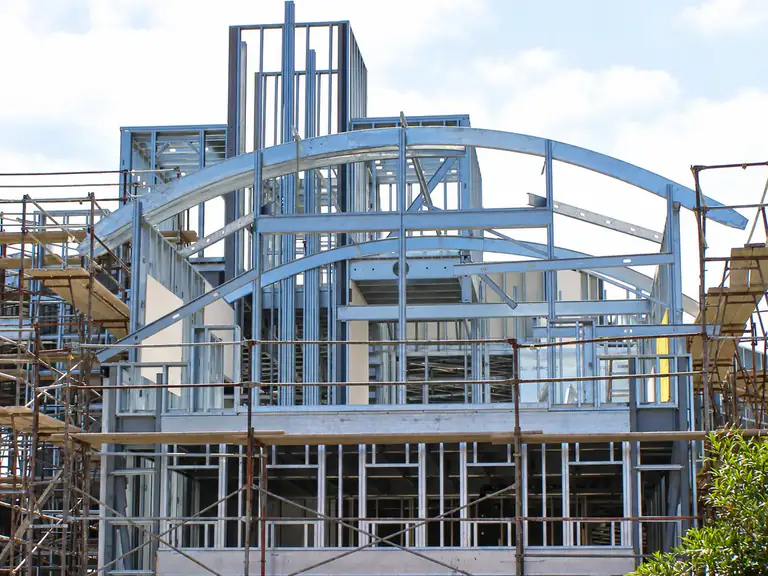 Custom arched cold-formed steel framing on a residential structure under construction.